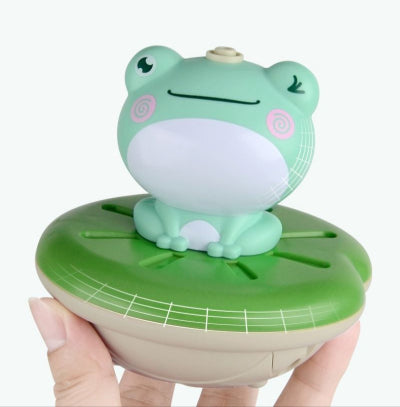 jouet de baignoire bébé grenouille main adulte